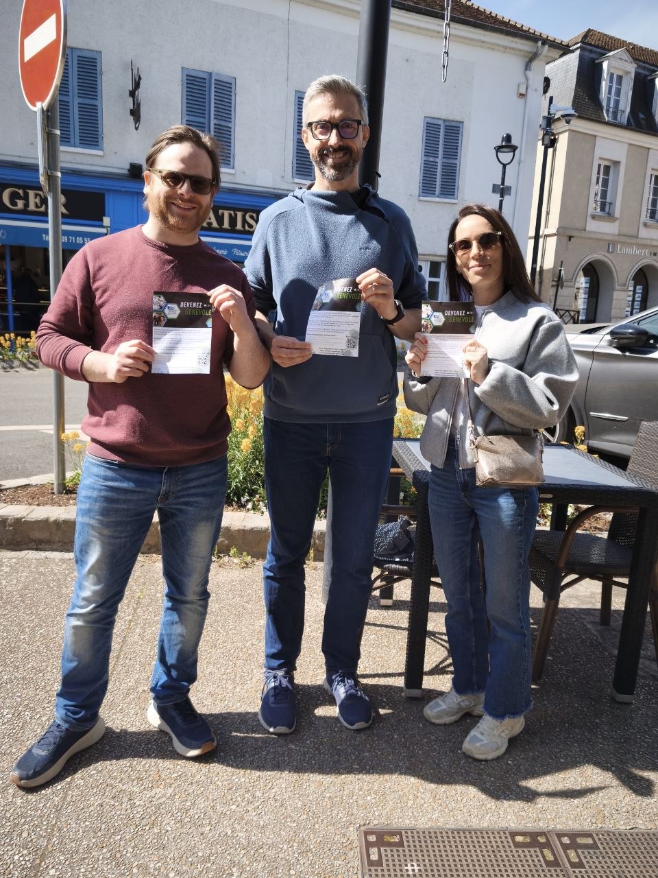 Trois bénévoles de Verneuil Numérique posant avec le flyer de recrutement dans les rues de Verneuil-sur-Seine